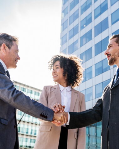 Multiracial group of business people bonding outdoors - International business corporate team wearing elegant suit meeting in a business park