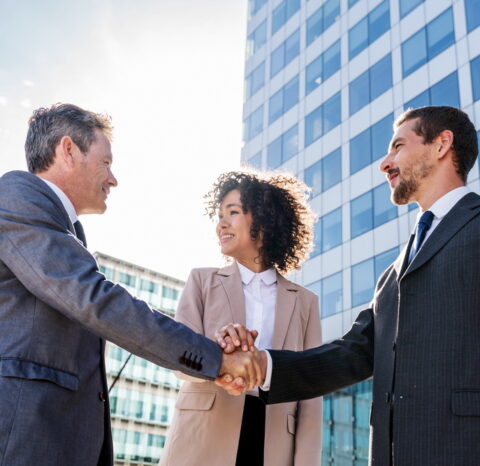 Multiracial group of business people bonding outdoors - International business corporate team wearing elegant suit meeting in a business park